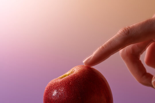 Index finger touch fresh red apple in isolated background