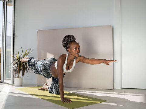 Fit black woman in expectancy training on mat