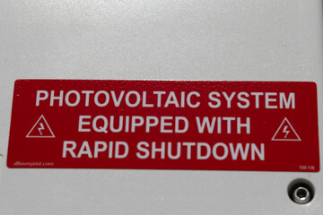 Close up of a sticker on electricity box saying that it uses photovoltaic system producing power from solar panels © Ivelin