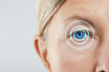 Vision test. Mature woman and digital scheme focused on her eye against white background, closeup