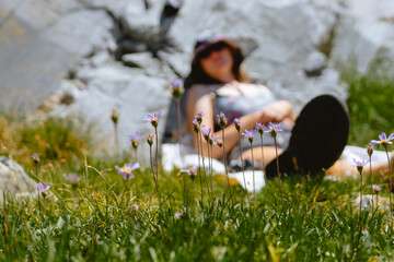 A woman relaxing in the grass with wildflowers in view.