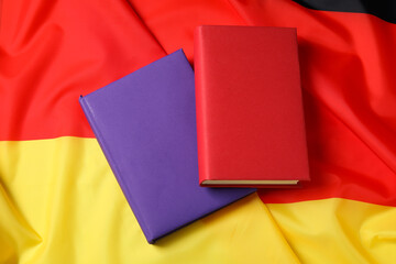 Learning foreign language. Different books on flag of Germany, top view