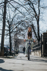 Casual young woman with long hair cycling on a city pathway with trees in the background on a clear day.