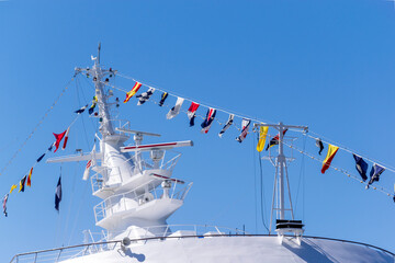青空に映える豪華客船のマストと信号旗