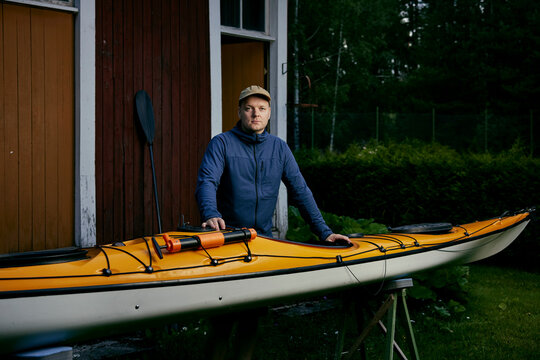 average finnish nordic man next to his yellow kayak