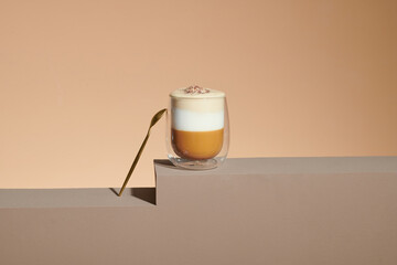 Cafe latte macchiato layered coffee in a see through glass coffee cup.