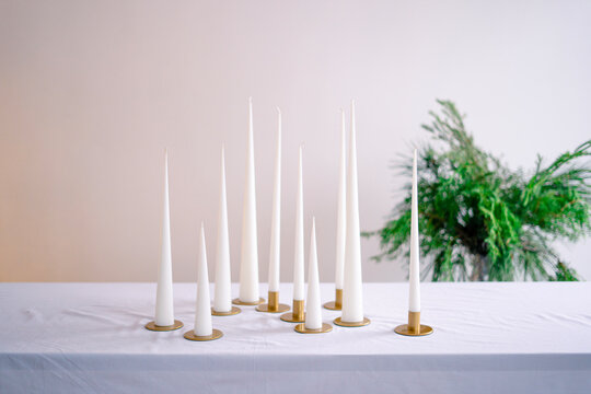 Elegant candlesticks with burning candles on white table
