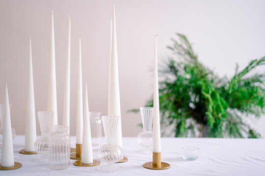 Elegant candlesticks with burning candles on white table
