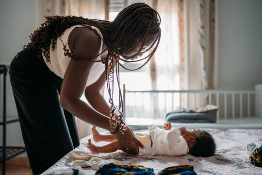 Young woman changing diaper to baby