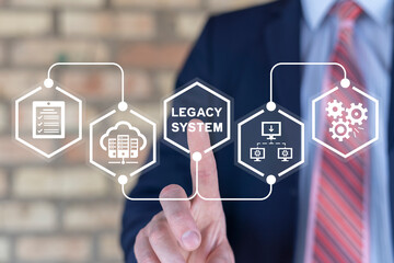 Businessman using virtual touch screen presses inscription: LEGACY SYSTEM. Legacy Systems Business...