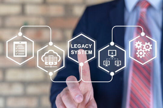 Businessman using virtual touch screen presses inscription: LEGACY SYSTEM. Legacy Systems Business Technology Interoperability Upgrade concept.