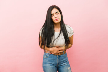 Sick young woman in pain because of cramps - obrazy, fototapety, plakaty