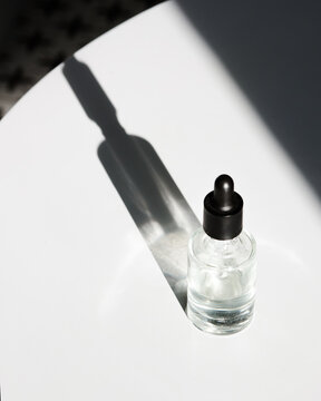 Glass bottle with beauty product in sunlight 