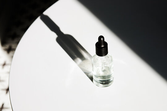 Glass bottle with beauty product in sunlight 