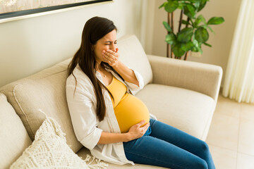Pregnant woman feeling sick at home and having health problems