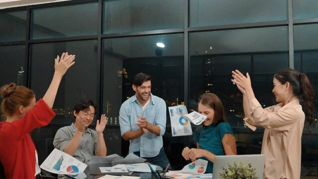 Professional happy businesspeople throw paperwork in the air while clapping hands to celebrate success. Group of smiling project manager put their hands on the air at modern office. Tracery