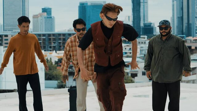 Professional hispanic break dancer practice B boy dance while multicultural friends at roof top. Young modern dancing group doing hip hop movement. Style,fashion,action. Outdoor sport 2024. hiphop.