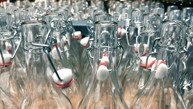 Rows of new glass bottles with swing top stoppers in a kitchenware store. Close-up shot