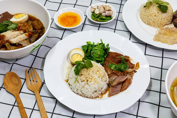 Stewed pork leg with boiled egg and rice on a plate.