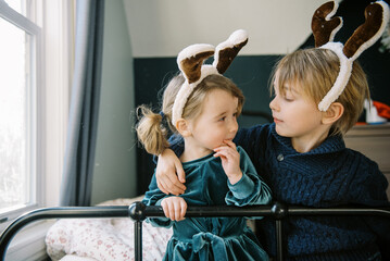brother and sister dressing up as reindeer smiling together
