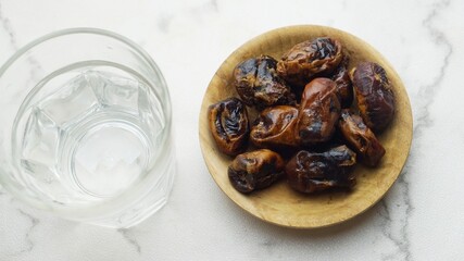Kurma or dates fruit with glass of mineral water. Traditional Ramadan, iftar meal. Ramadan kareem fasting month concept