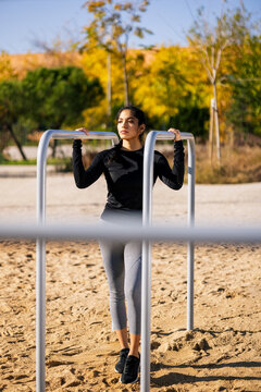 female athlete standing near parallel bars during calisthenics workout
