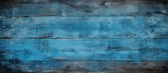 A blue grunge texture serves as a backdrop for an empty wooden table, while a black overlay adds contrast and depth to the composition. - obrazy, fototapety, plakaty