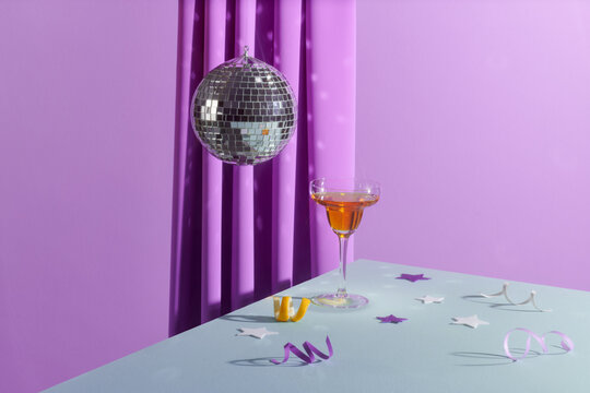 Martini with ice in an elegant glass of disco balls on a shiny