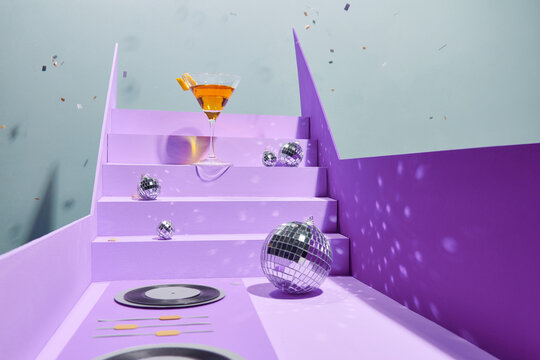 orange cocktail with sparkling disco ball background