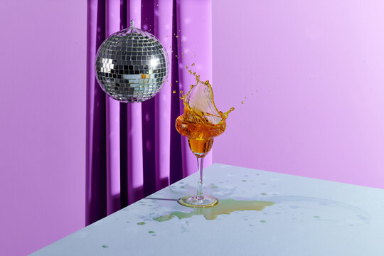 Stemmed cocktail glass with orange liquor splashing out