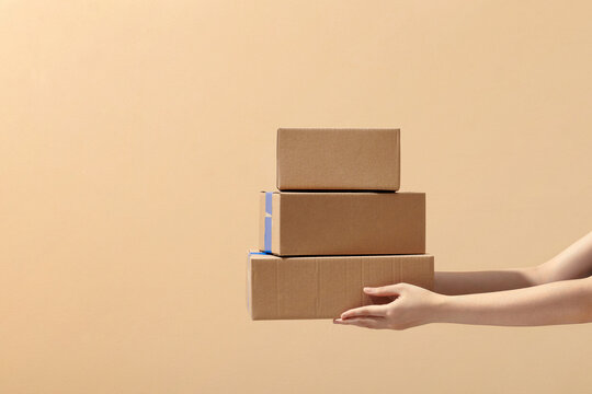 Hand holding brown cardboard boxes