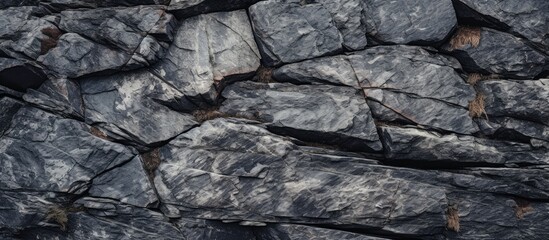 A black and white close-up shot of large granite rocks, showcasing their texture and details. The rocks appear rugged and massive, dominating the frame with their imposing presence.