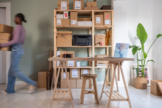 Female employee leaving office with ready parcels