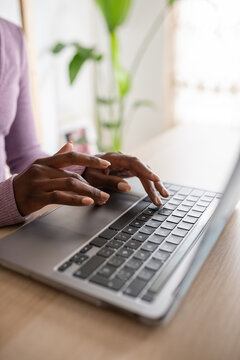 Crop black female entrepreneur using computer for work