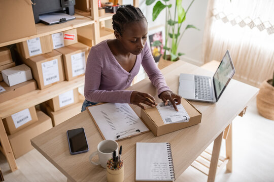 Black employee checking delivery data on label