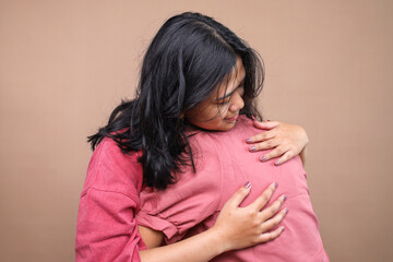 Fototapeta premium Two young Asian women embracing each other at home.