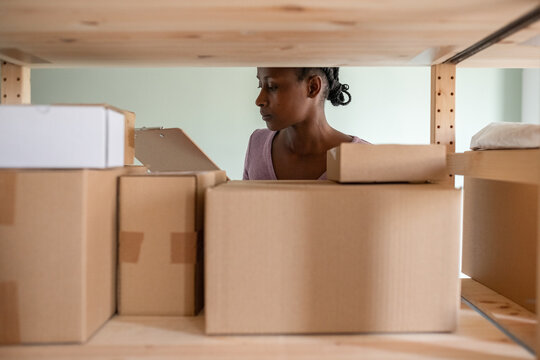 Black employee checking boxes and reading information