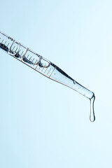 Clear liquid droplets falling from a dropper that can be used for cosmetic and medical images.