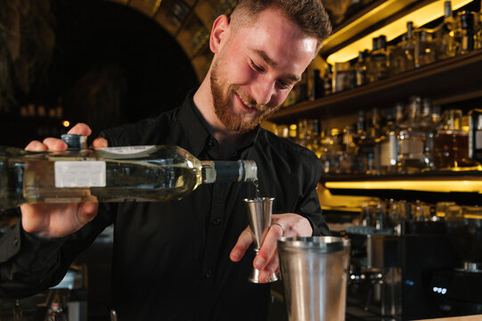 Delighted barman measure booze with jigger