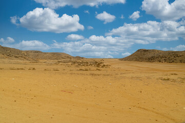 Fototapeta na wymiar Arid landscape in Punta Gallinas desert and blue sky. Guajira, Colombia.