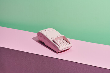 POS portable credit card machine and credit card isolated on pink