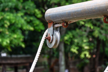pulley hook dangling on beam pipe Rusty with rope in tree view