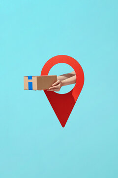 Hand of the courier man holding delivery package in location pin