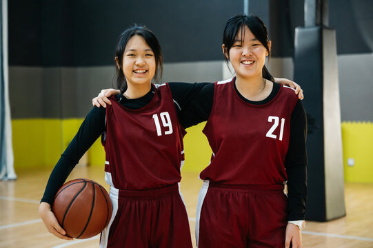 Portrait of two basketball girls team in a gym