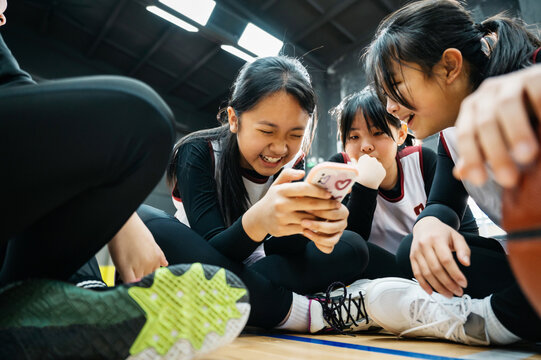 Teenager girls sitting on floor in gym