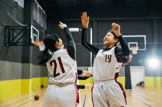 Basketball team high fiving in gym