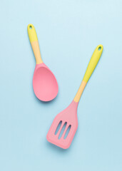 Silicone spoon and spatula on a blue background.