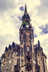 Fototapeta na wymiar Behold the commanding presence of Glasgow's urban landscape with this captivating photo featuring a tall building crowned by a majestic clock tower.