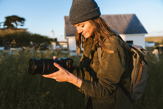 Woman Using Camera Taking Photos Outside at Golden Hour