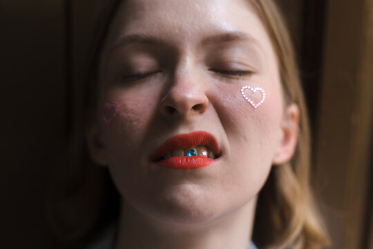 Portrait of unconventional woman with tooth stickers and red lips